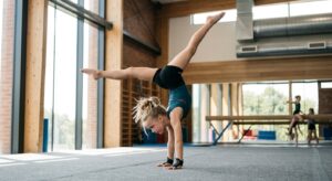A professional, editorial-style photograph of a focused young child performing a graceful acrobatic