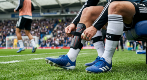 High-quality editorial photograph of a professional soccer player’s legs getting ready for a match,
